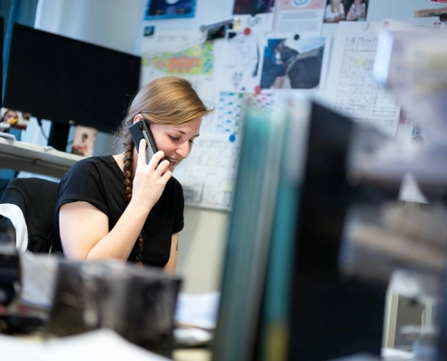 Frau telefoniert an ihrem Arbeitsplatz